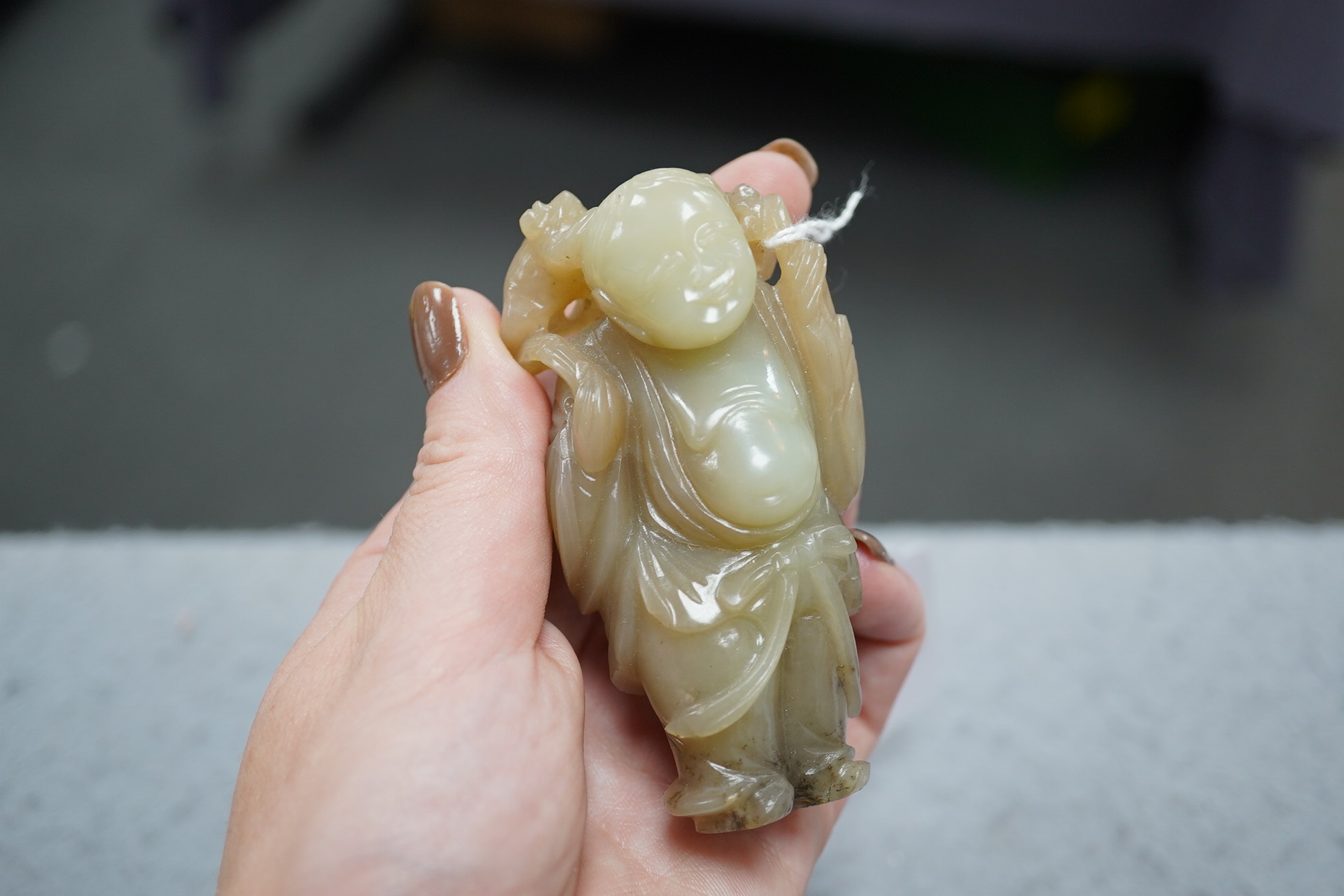 A Chinese pale celadon and brown jade group of Liu Hai and his three legged toad, Qianlong period (1736-95)